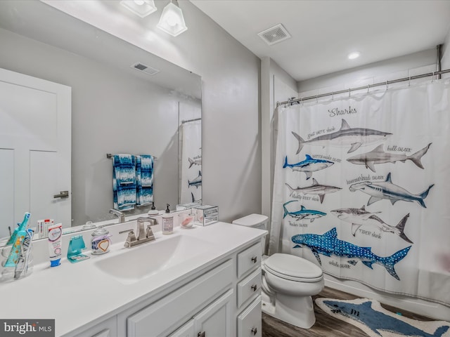 bathroom with hardwood / wood-style floors, toilet, vanity, and a shower with curtain