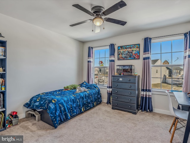 bedroom with ceiling fan, multiple windows, and light carpet