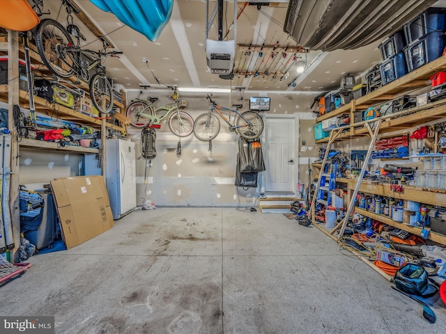 garage with a garage door opener and white refrigerator