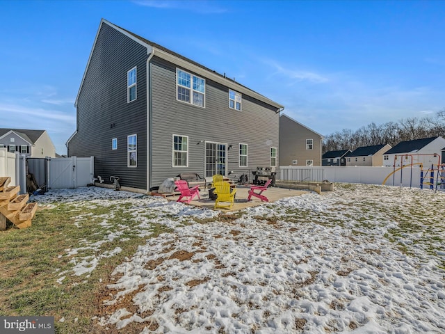 snow covered rear of property with a patio