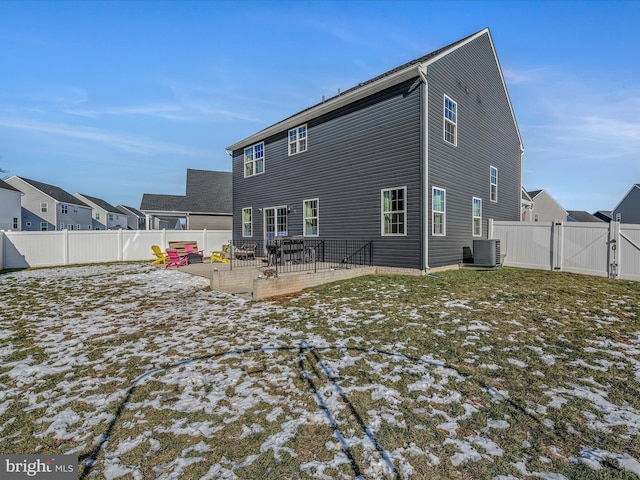 snow covered house featuring a patio area and central AC unit