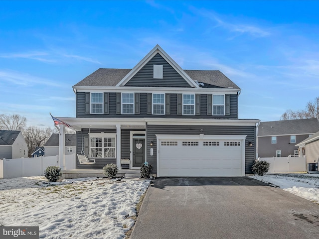 view of front of house with central AC, a garage, and a porch