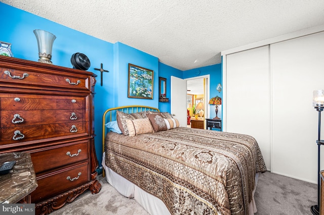 carpeted bedroom with a closet and a textured ceiling