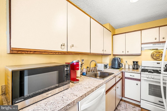 kitchen featuring a textured ceiling, sink, white cabinets, and white appliances