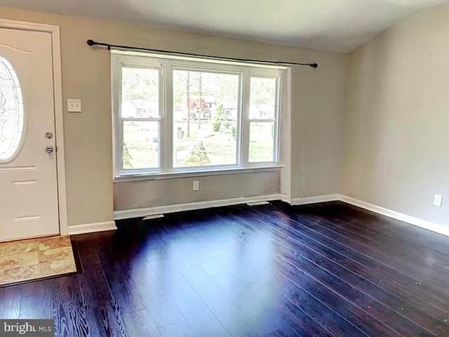 entrance foyer featuring dark hardwood / wood-style flooring and lofted ceiling