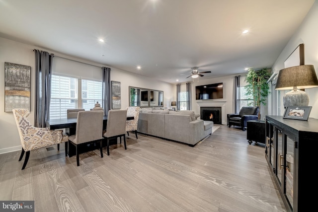 living room with light hardwood / wood-style flooring and ceiling fan