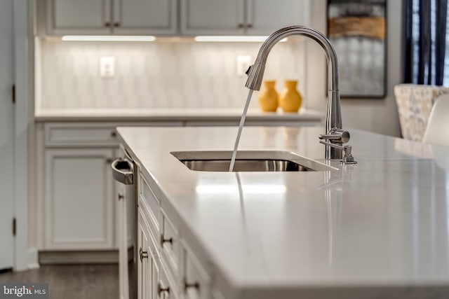 kitchen featuring dishwasher, sink, and white cabinets