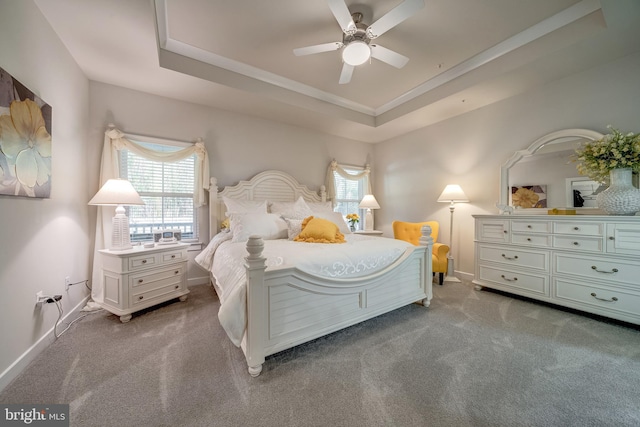 bedroom featuring light colored carpet, ceiling fan, and a tray ceiling