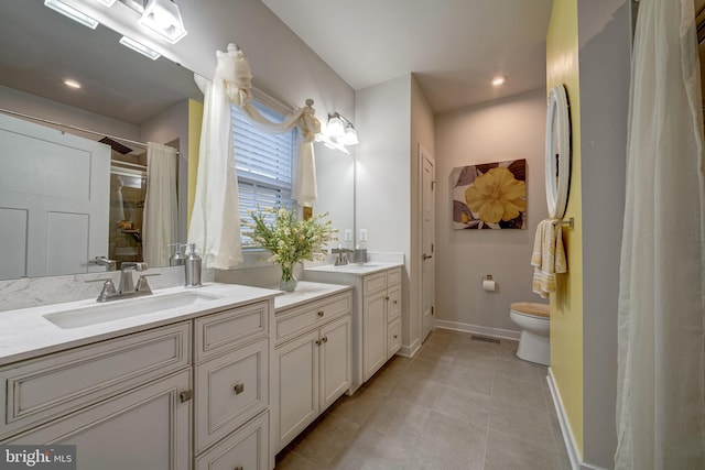 bathroom with vanity, toilet, and tile patterned flooring