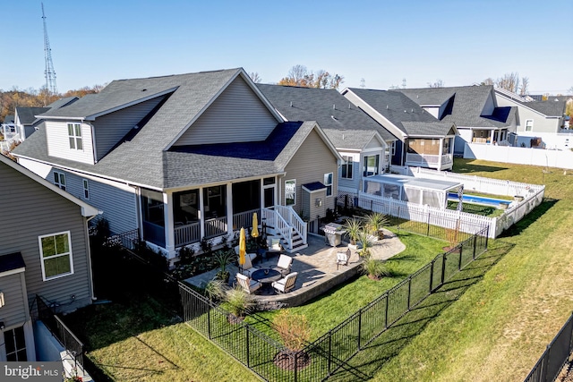 rear view of property featuring an outdoor fire pit, a patio, and a lawn