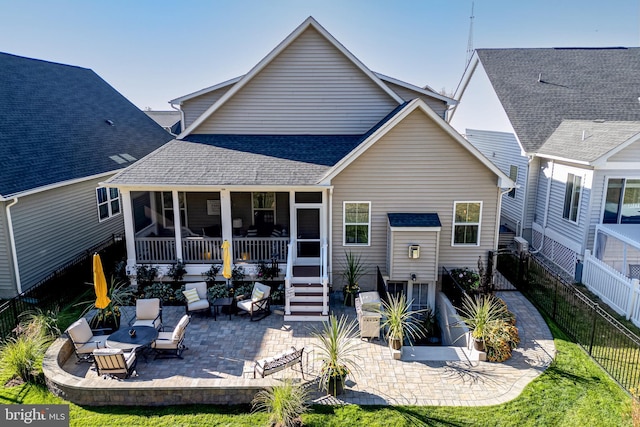 rear view of property with a sunroom and a patio