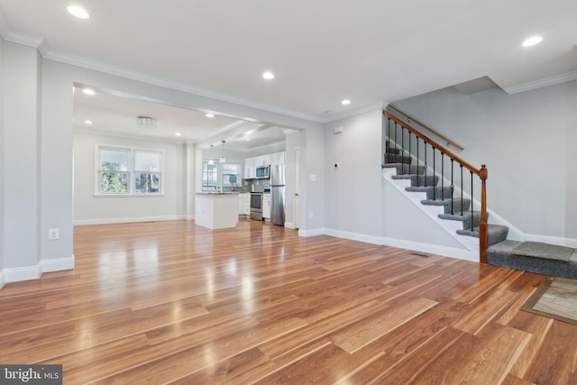 unfurnished living room featuring crown molding and light hardwood / wood-style flooring