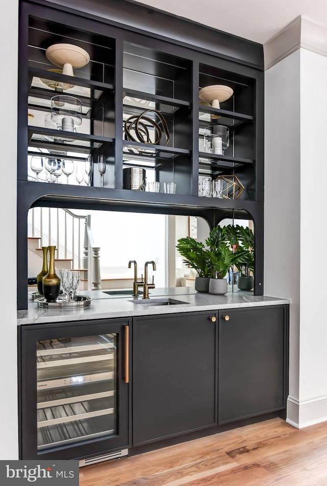 bar with wine cooler, hardwood / wood-style floors, and sink