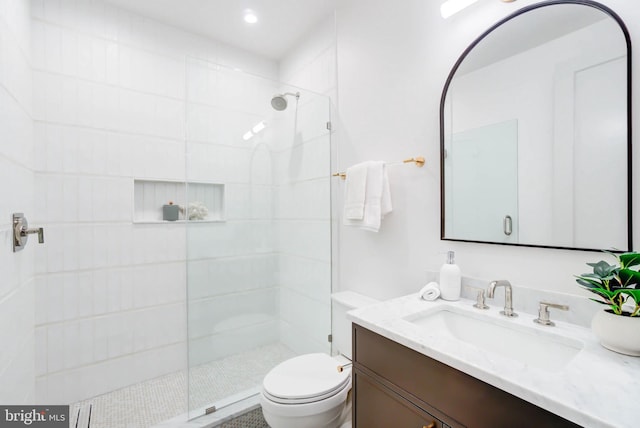 bathroom featuring vanity, toilet, and a shower with door