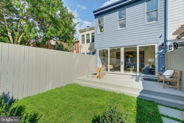 rear view of house with a deck and a lawn