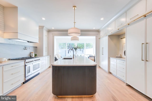 kitchen with pendant lighting, white cabinets, double oven range, and custom range hood