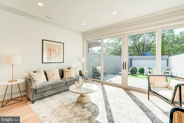 living room with light hardwood / wood-style flooring and crown molding