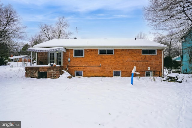 view of snow covered back of property