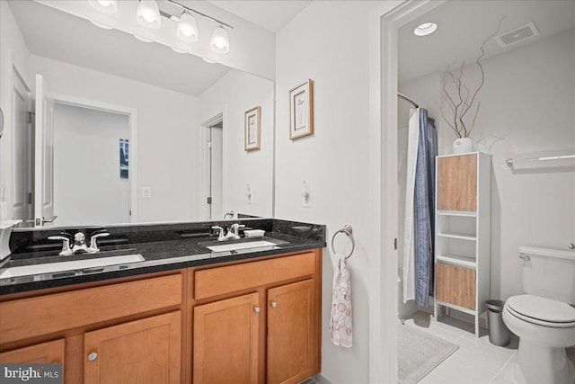 bathroom with vanity, tile patterned floors, and toilet