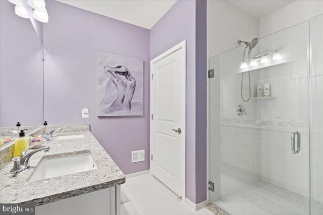 bathroom with a shower with door, tile patterned flooring, and vanity