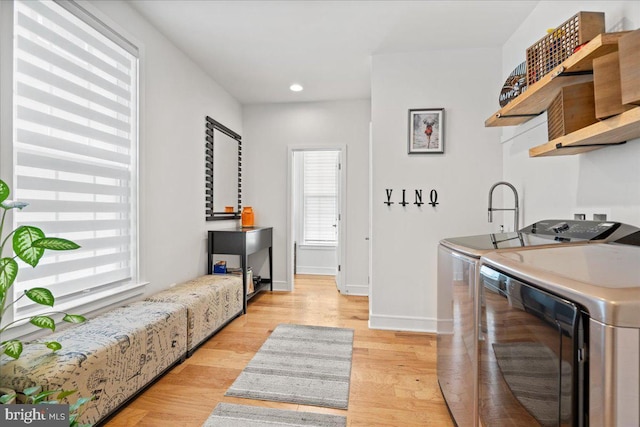 kitchen with light wood-type flooring and washing machine and clothes dryer