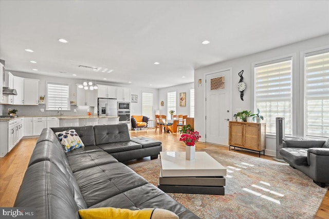 living room with a healthy amount of sunlight, light wood-type flooring, and sink