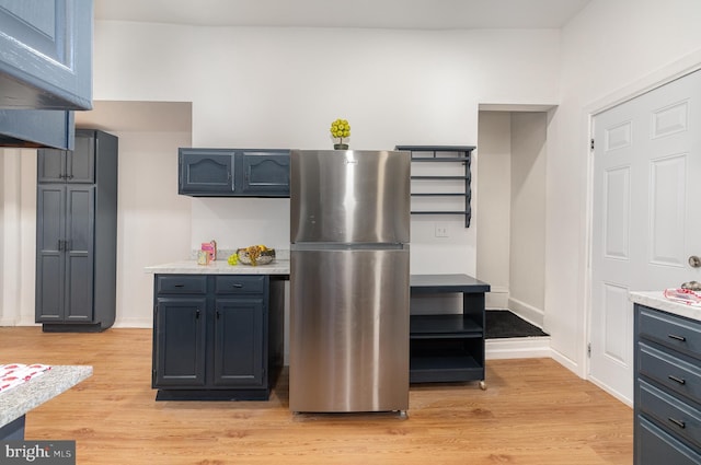 kitchen featuring stainless steel fridge and light hardwood / wood-style flooring