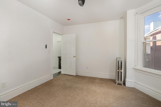 carpeted spare room featuring radiator