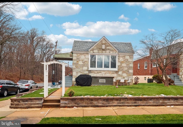 view of front facade featuring a front lawn and central air condition unit