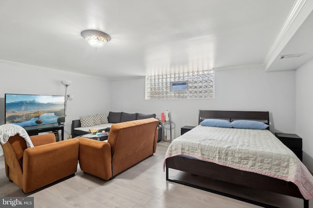 bedroom with crown molding and light wood-type flooring