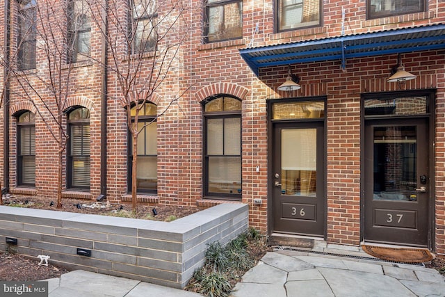 doorway to property with brick siding