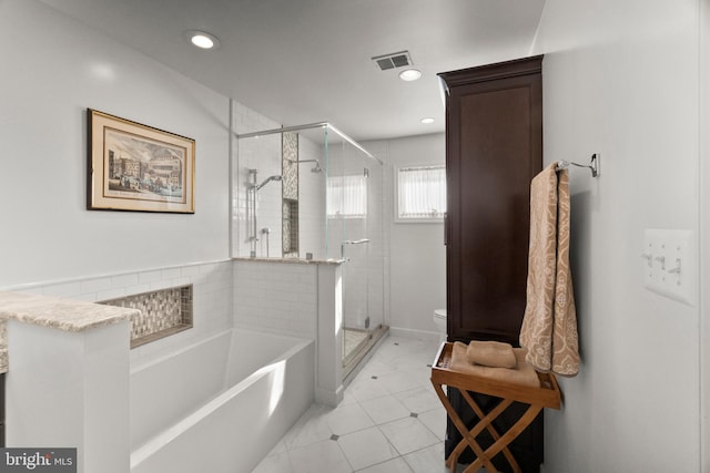 bathroom featuring toilet, tile patterned flooring, and separate shower and tub