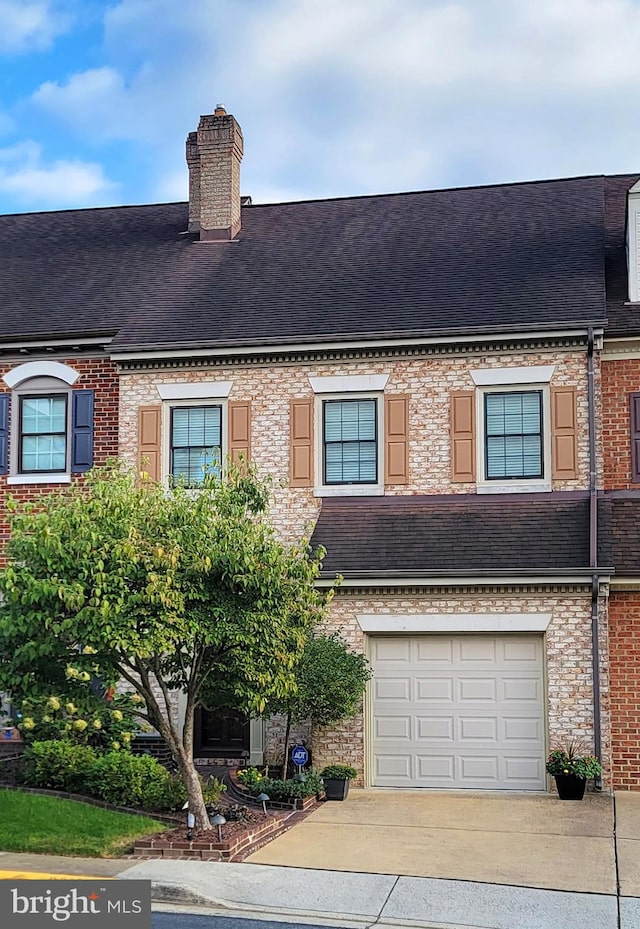 view of property featuring brick siding, a chimney, a shingled roof, concrete driveway, and a garage