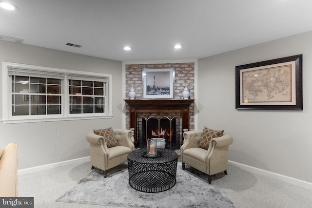 sitting room with carpet floors and a brick fireplace