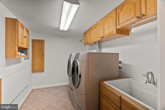 washroom with cabinets, washer and clothes dryer, and sink