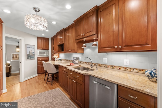 kitchen with built in microwave, dishwasher, sink, light hardwood / wood-style flooring, and pendant lighting