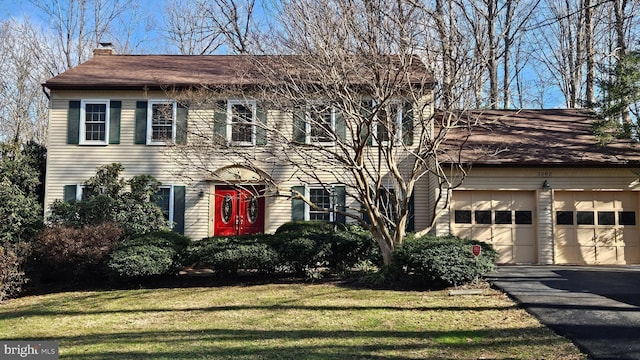 colonial-style house with a garage and a front yard