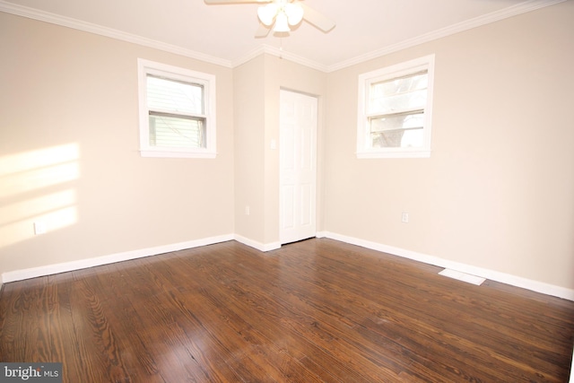 empty room featuring dark wood finished floors, ceiling fan, crown molding, and baseboards