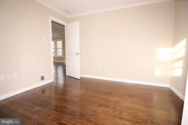 spare room with dark wood finished floors, crown molding, baseboards, and visible vents