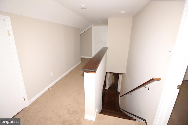 staircase with baseboards, lofted ceiling, and carpet floors