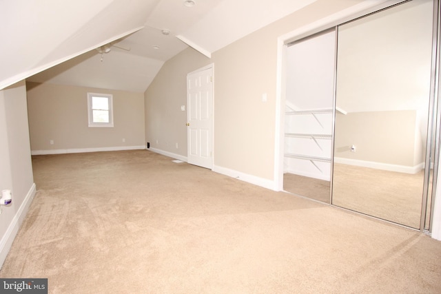 additional living space with baseboards, carpet, and vaulted ceiling