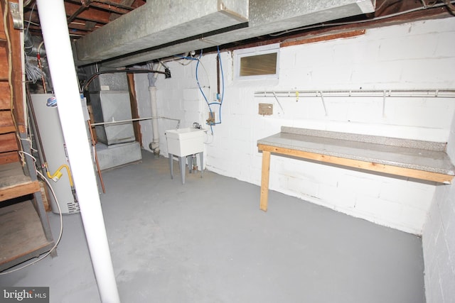 unfinished basement with gas water heater and a sink