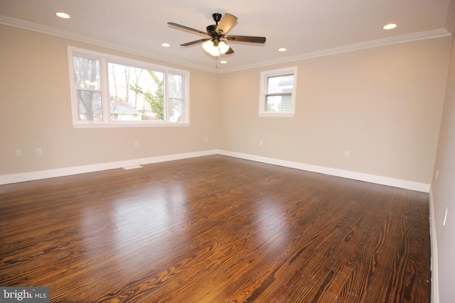 spare room with dark wood finished floors, recessed lighting, crown molding, and baseboards