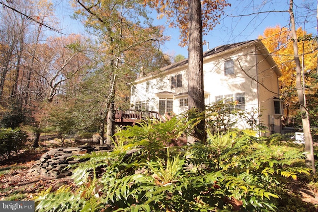 view of property exterior with a wooden deck