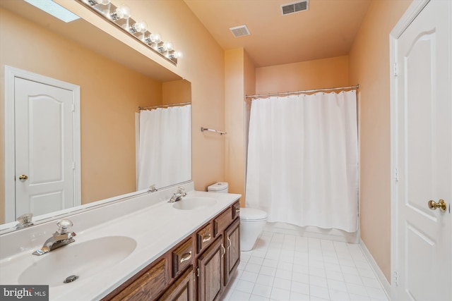 full bathroom featuring vanity, toilet, a skylight, and shower / tub combo