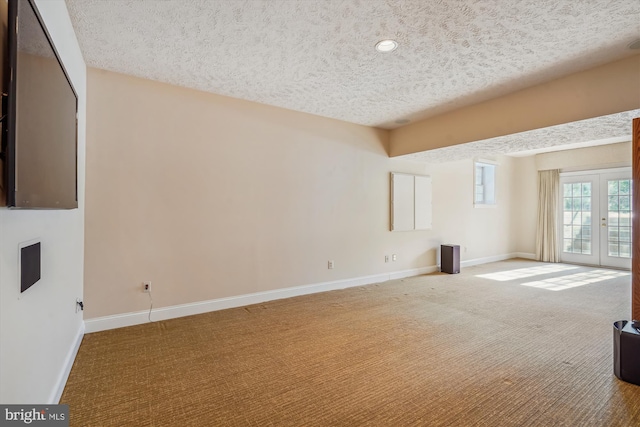 unfurnished living room with french doors, carpet floors, and a textured ceiling