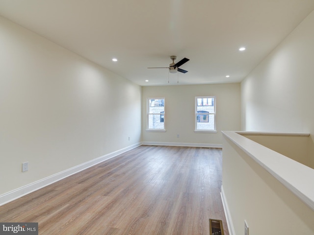 unfurnished room with light wood-type flooring and ceiling fan