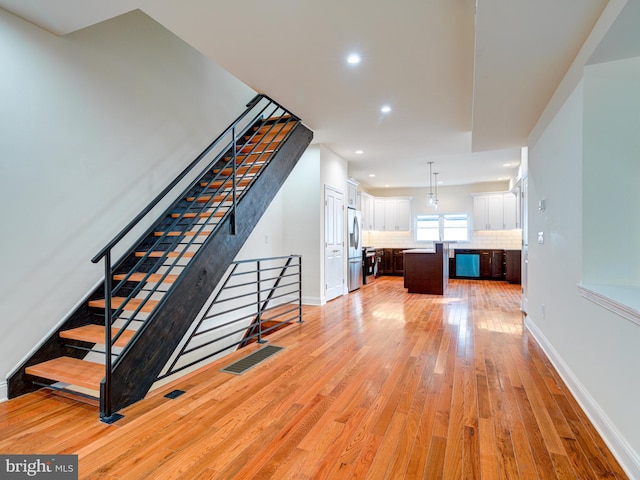 staircase with hardwood / wood-style floors