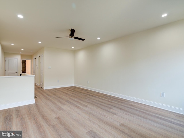 empty room with ceiling fan and light hardwood / wood-style flooring