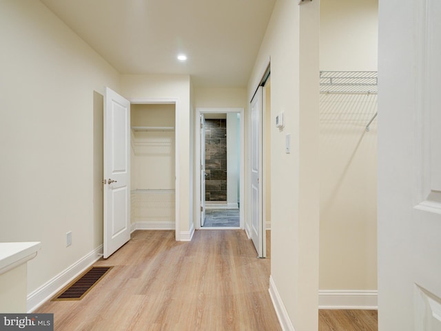 hallway with light hardwood / wood-style flooring